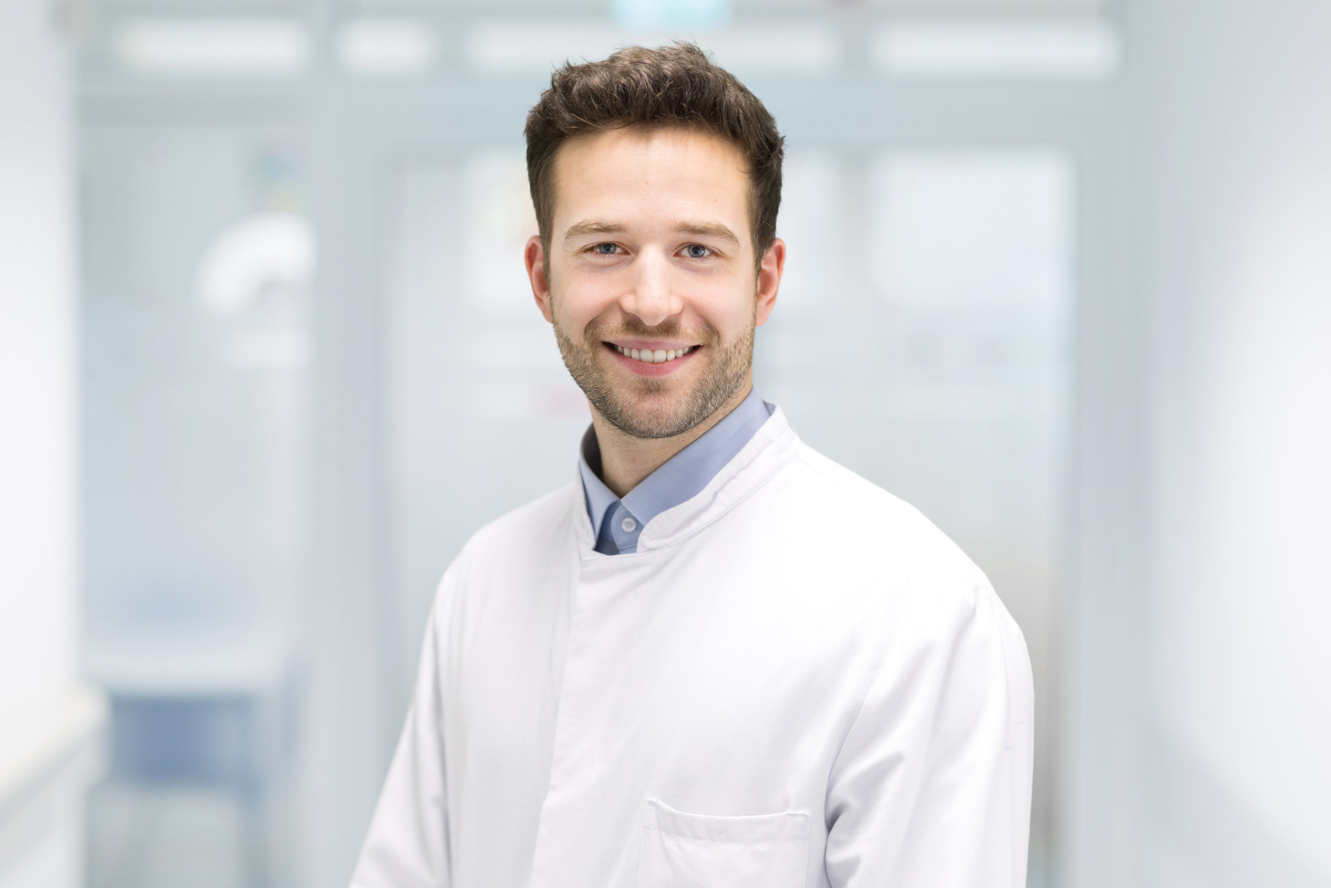 Portrait von Philip Lutz im weißen Kittel